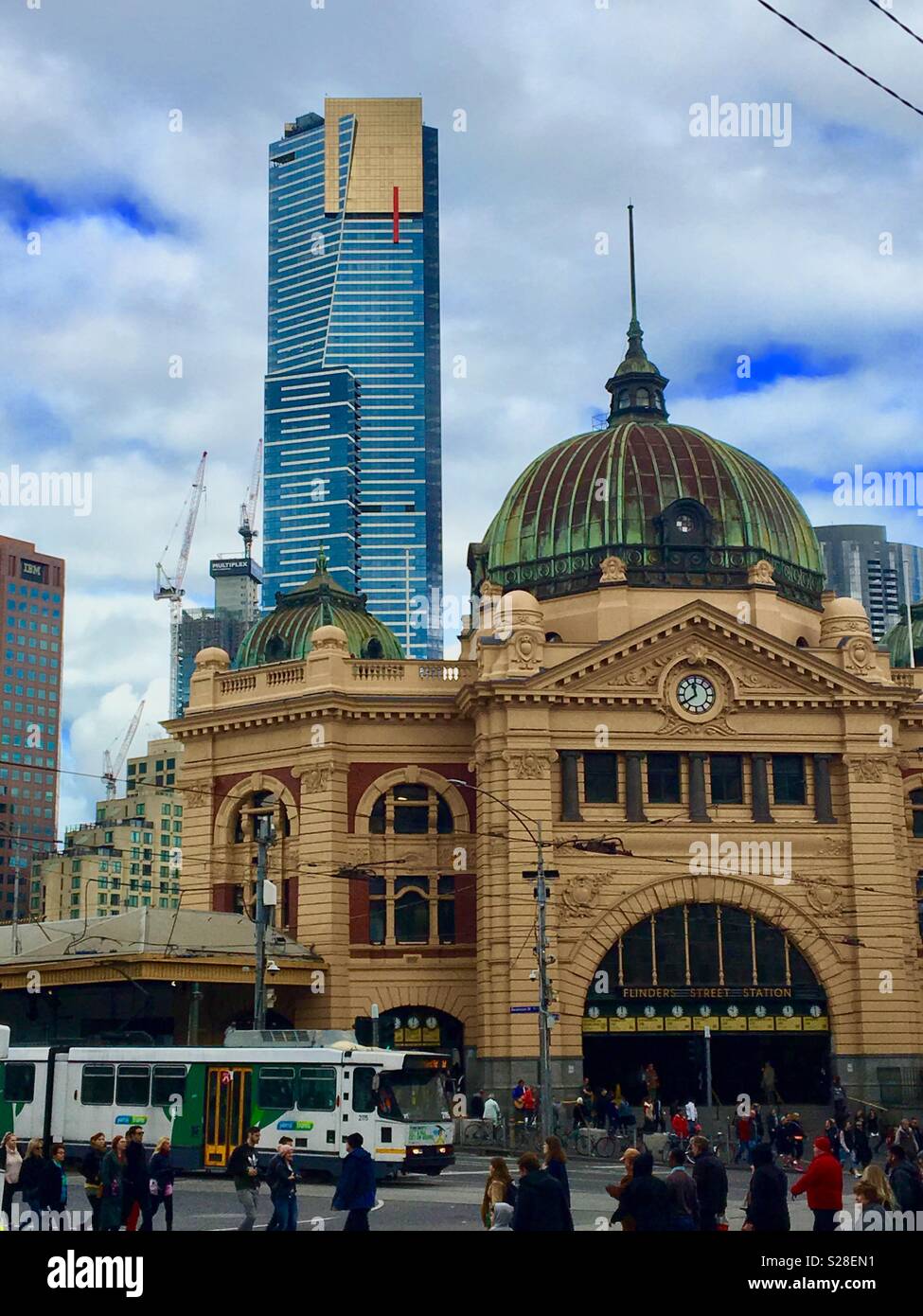 La stazione di Flinders Street con Eureka Skytower e tram con persone che attraversano la Flinders Street a Melbourne in Australia Foto Stock