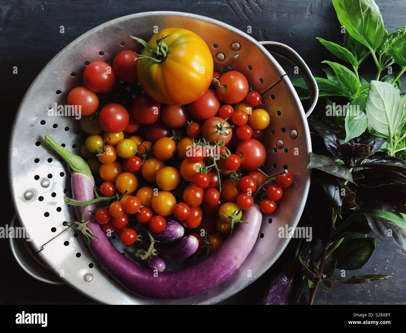 Giardino urbano raccolto di pomodori, melanzane e basilico. - Immagine stock catturata con smartphone