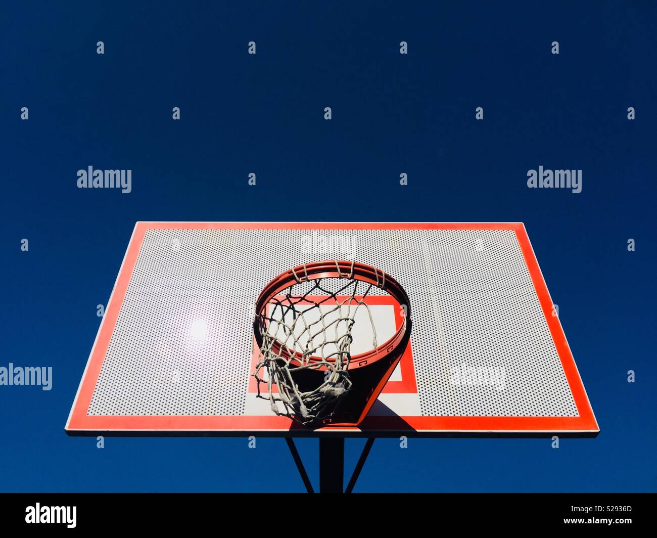 Un parco giochi Basketball hoop con un rip net isolata contro il cielo - Immagine stock catturata con smartphone