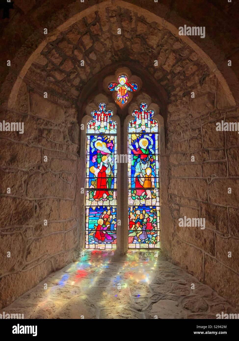 La luce del sole attraverso una finestra di vetro colorato nella cappella di San Michele di monte, Cornwall Foto Stock
