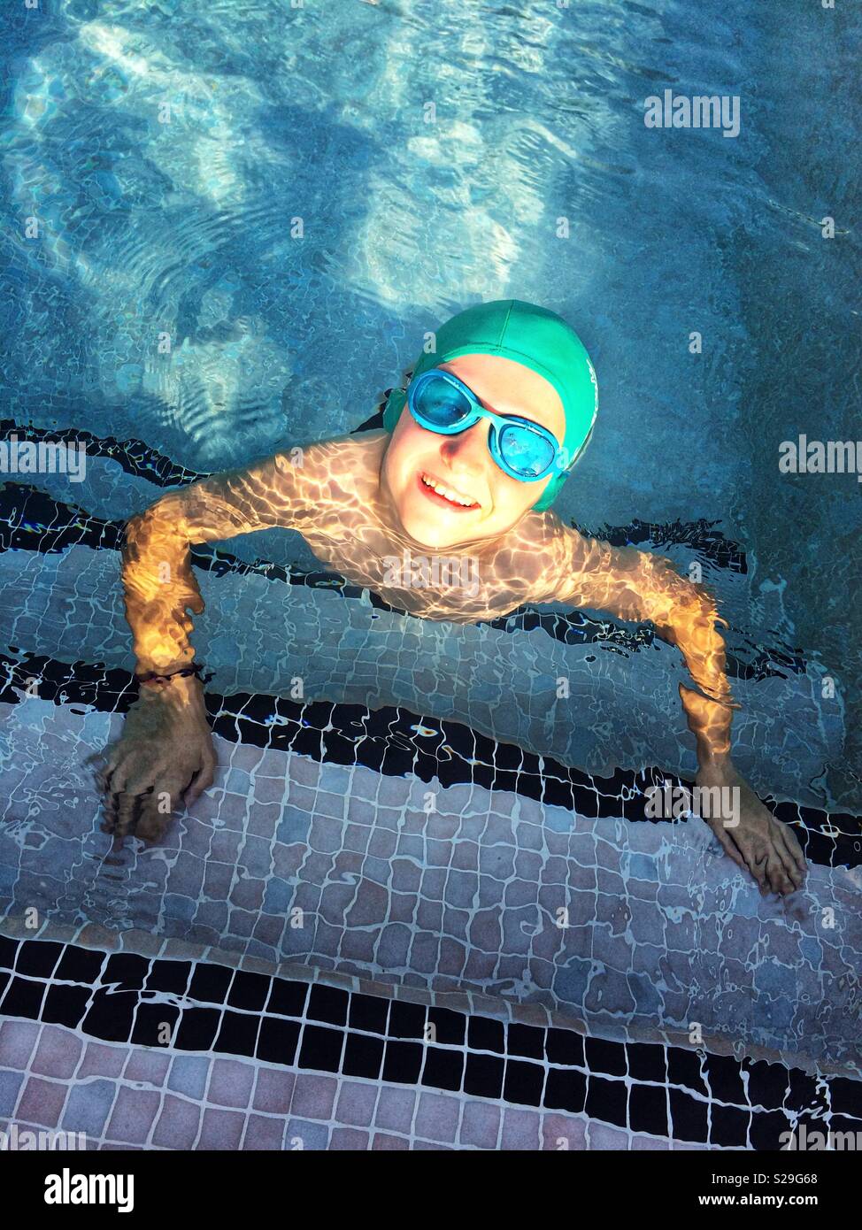 Ragazzo sorridente in una piscina Foto Stock