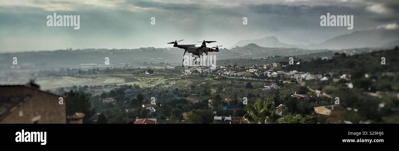 Piccolo drone battenti sulle colline a Calpe, Spagna - Immagine stock catturata con smartphone