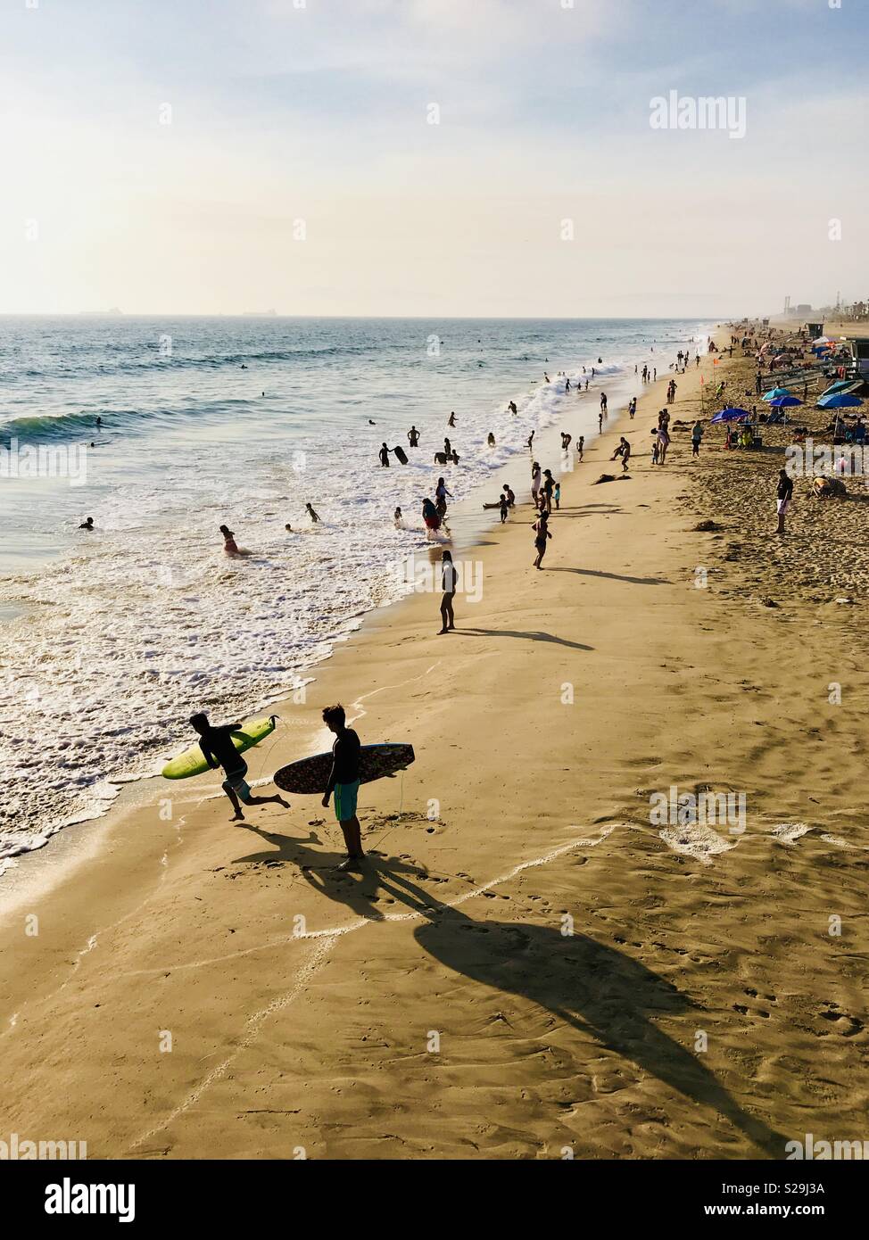Frequentatori di spiaggia giocare in acqua durante una calda giornata estiva. Manhattan Beach, California USA. Foto Stock