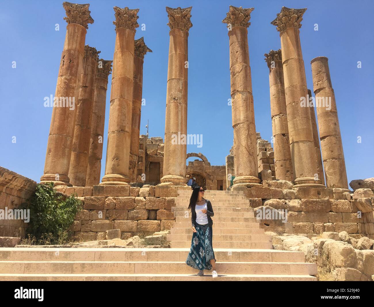 "Dove mi trovo?" - un asiatico giovane donna di fronte la chiesa bizantina ruderi in Giordania, Medio Oriente Foto Stock