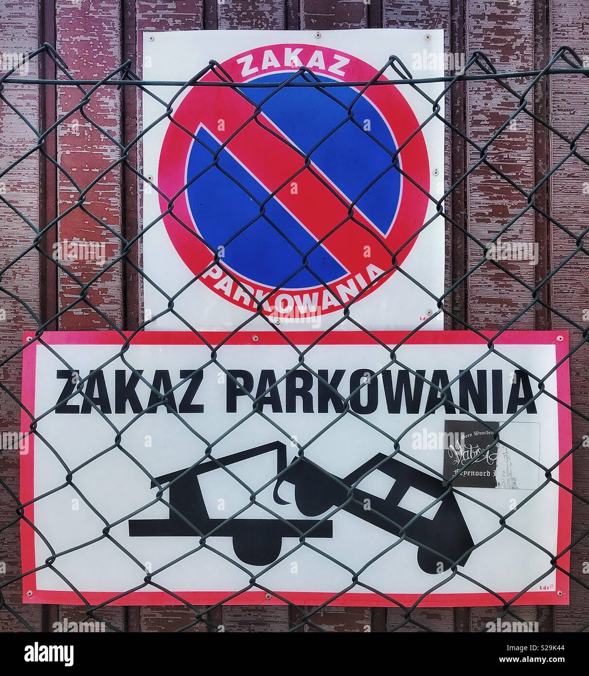 Un segno di avvertimento non driver per parcheggiare il proprio veicolo senza autorizzazione nella ristretta trainare zona. Il segno è in lingua polacca. - Immagine stock catturata con smartphone
