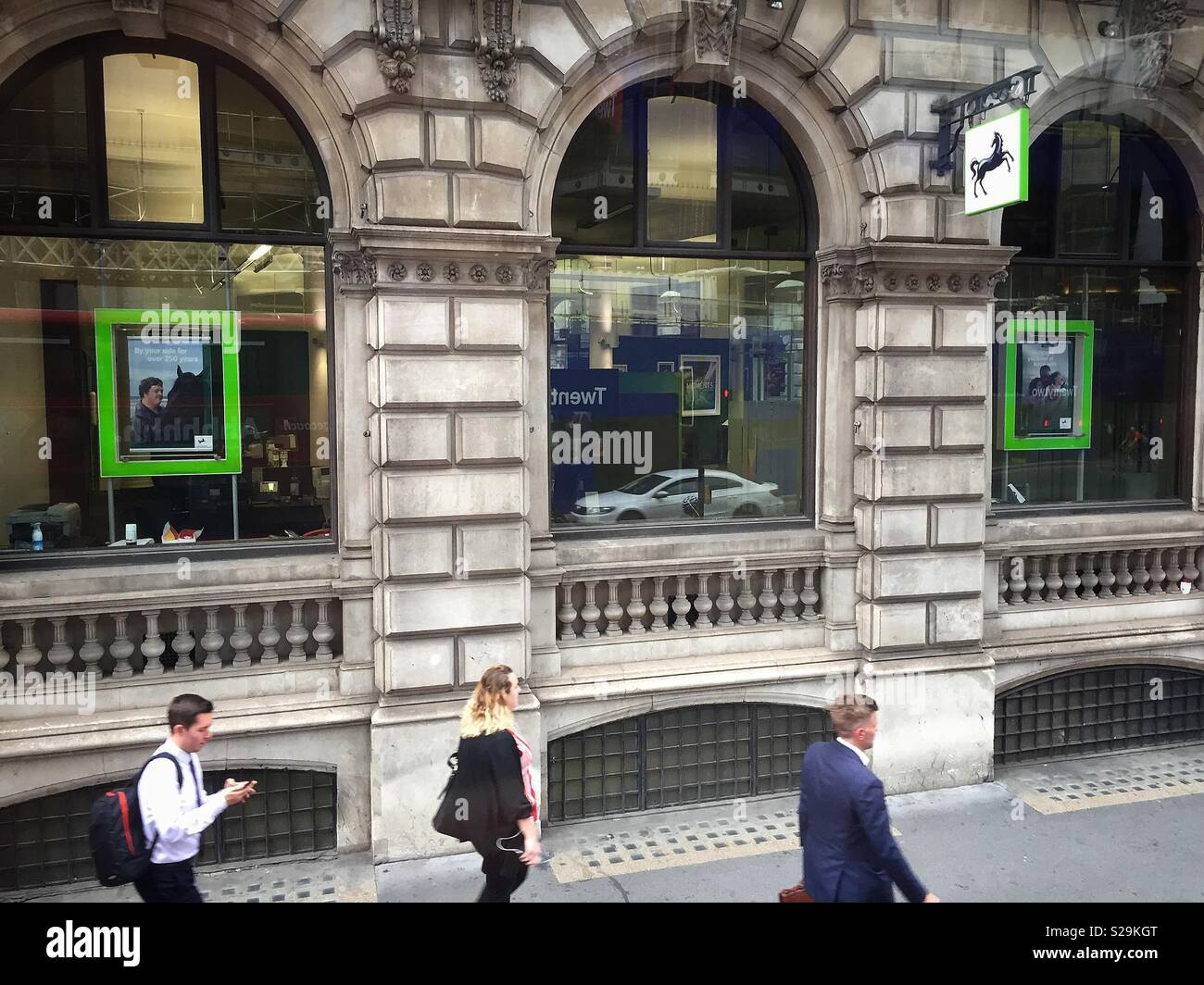 La gente a piedi passato Lloyd's Bank, City of London, Moorgate. Regno Unito Foto Stock