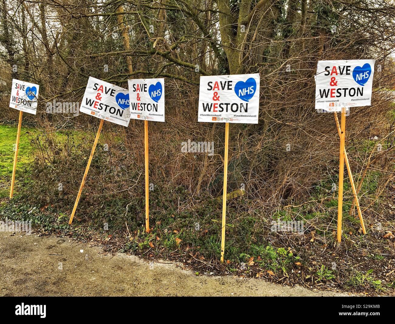 Cartelloni con lo slogan "SALVA WESTON A&E" in una dimostrazione contro i tagli a Weston Ospedale Generale di Weston-super-Mare, Regno Unito il 6 febbraio 2018 - Immagine stock catturata con smartphone