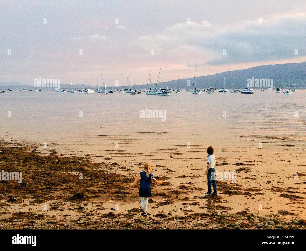I bambini sulla spiaggia al tramonto Foto Stock