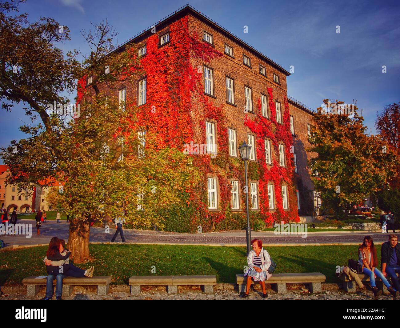 Persone relax su una panchina presso il castello di Wawel su un bello e colorato giornata autunnale, Cracovia in Polonia Foto Stock