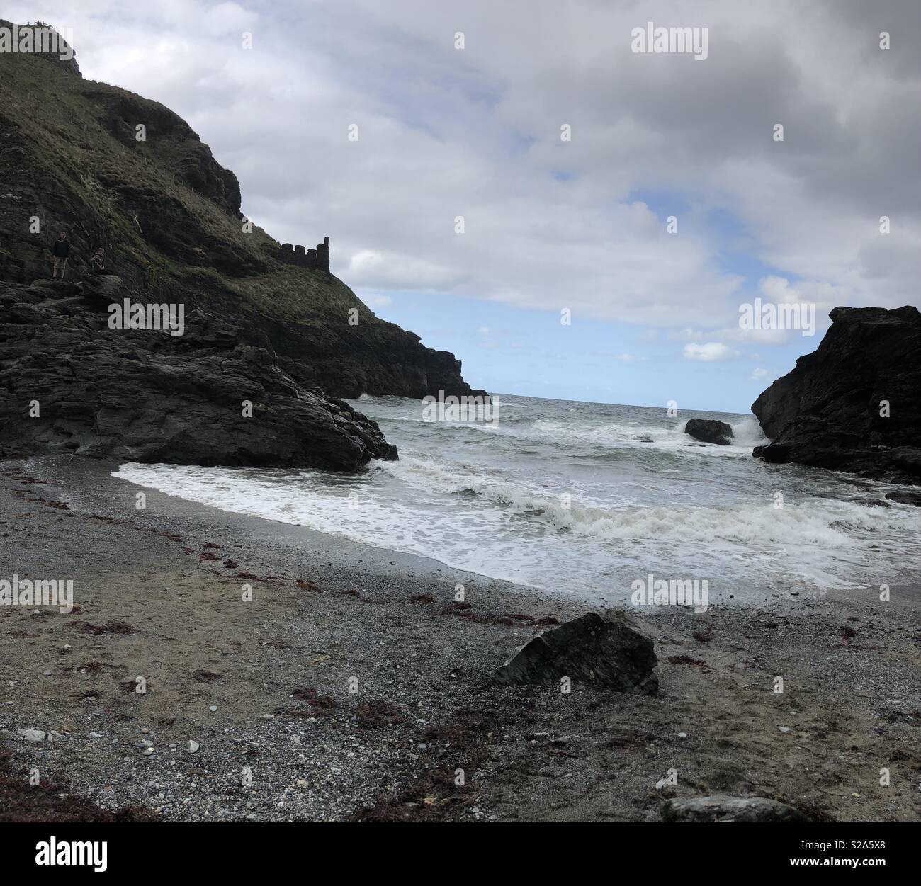 Tintagel beach in Cornwall Regno Unito guardando Tintagel Castle in lontananza sulla sinistra Foto Stock