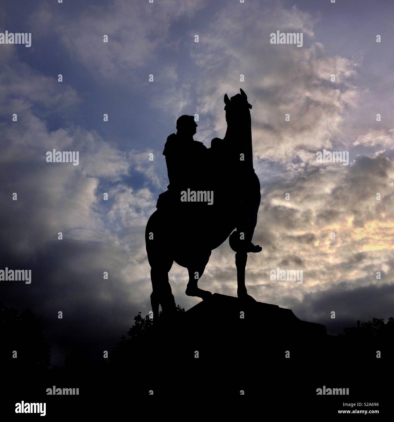 Una statua equestre di Guglielmo III di Queen Square, Bristol, Regno Unito stagliano nuvole drammatico al tramonto Foto Stock