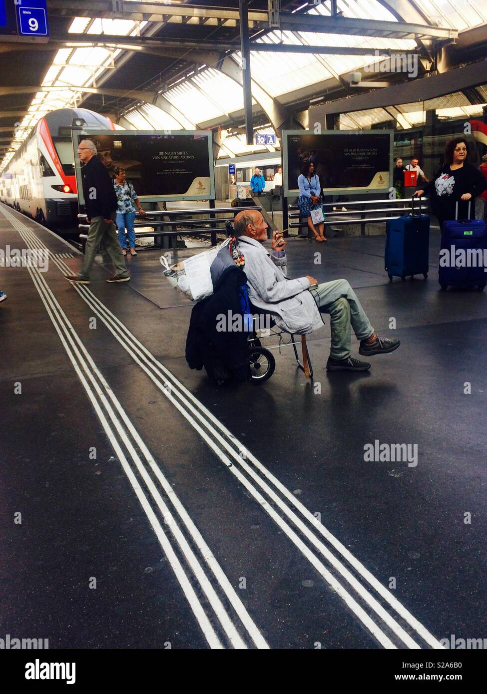 I pendolari ferroviari o ferroviari attendono alla stazione centrale di Zurigo o alla stazione ferroviaria principale per prendere i treni e scoprire la vita quotidiana, i viaggi e i trasporti - Immagine stock catturata con smartphone