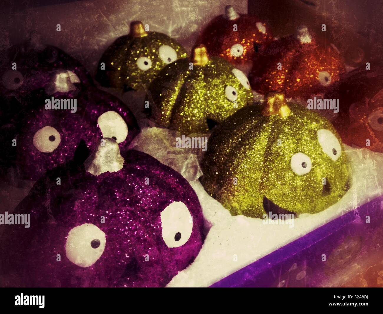 Glittery viola, verde e arancione zucca facce per la vendita Foto Stock