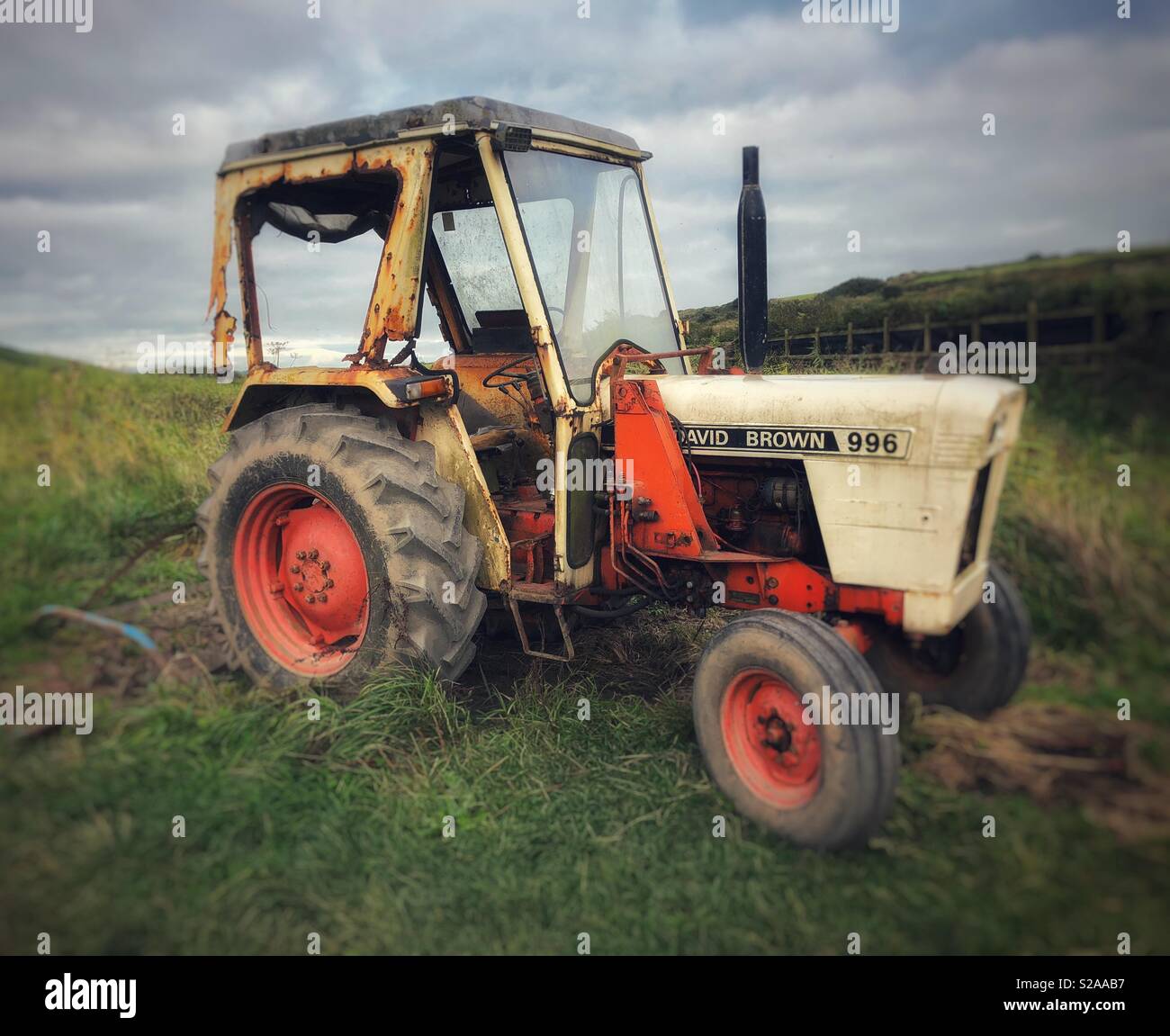 Un vecchio trattore in un campo a Abereiddy nel Galles Occidentale. Foto Stock