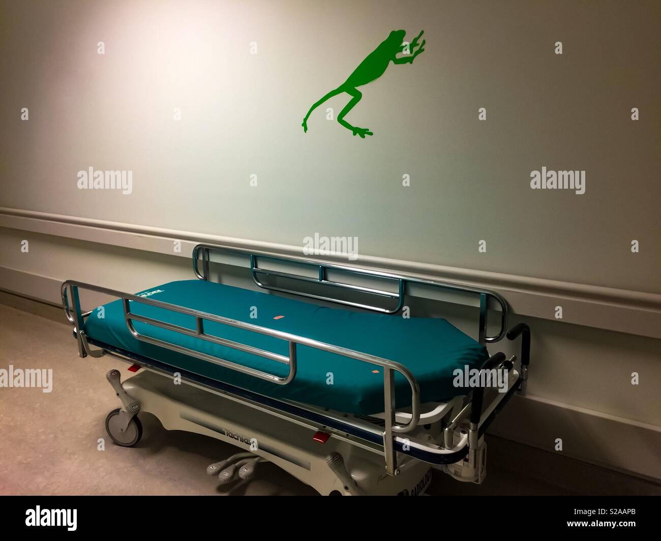 Vuoto letto di ospedale e saltando rana verde - Immagine stock catturata con smartphone