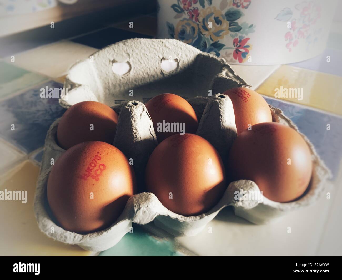 Scatola di colore marrone sei uova di galline su un piano di lavoro Foto Stock