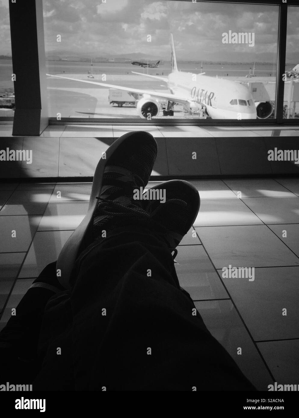 Rilassante con i piedi sulla mia bagagli all'Aeroporto Internazionale di Città del Capo a bordo di un volo - Immagine stock catturata con smartphone