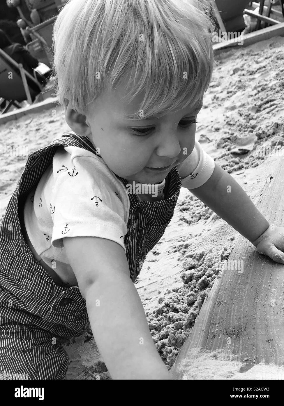 Il Toddler boy giocando nella buca di sabbia Foto Stock