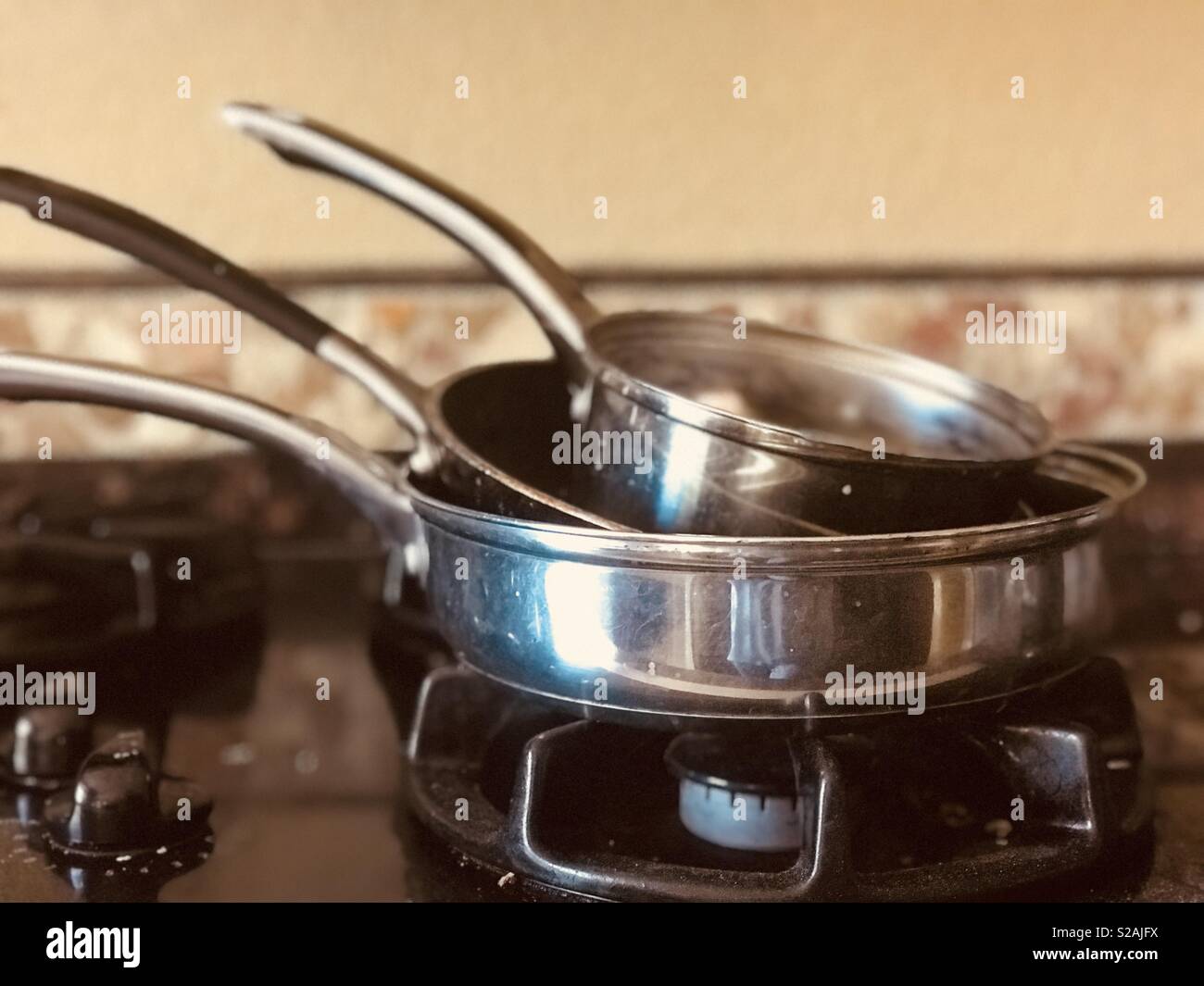 Set di pentole e padelle impilate sulla stufa in cucina. - Kitchenwares  Foto stock - Alamy