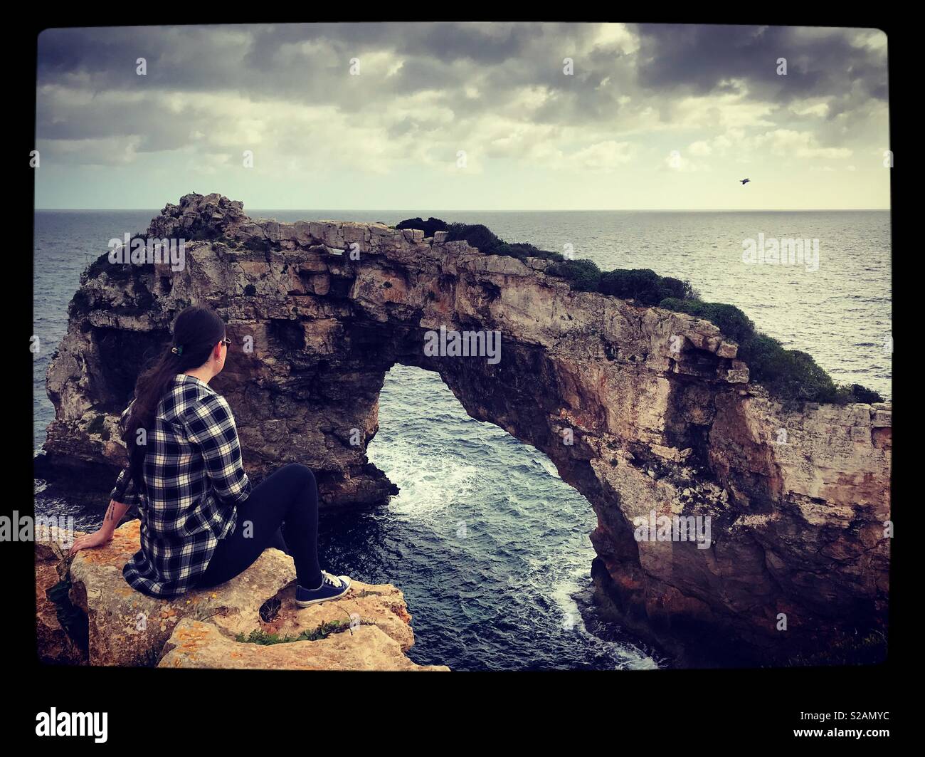Donna sul bordo sulla scogliera che guarda a Es Pontas, Mallorca Foto Stock