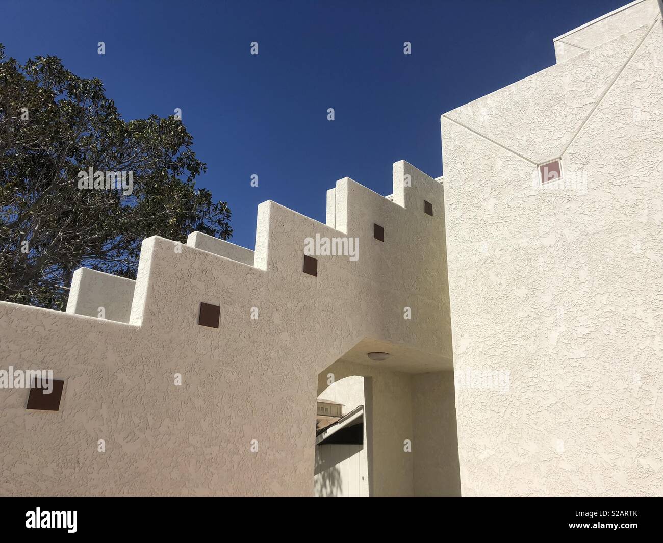 Dettagli architettonici di una parete in stucco con cielo blu sullo sfondo. Foto Stock