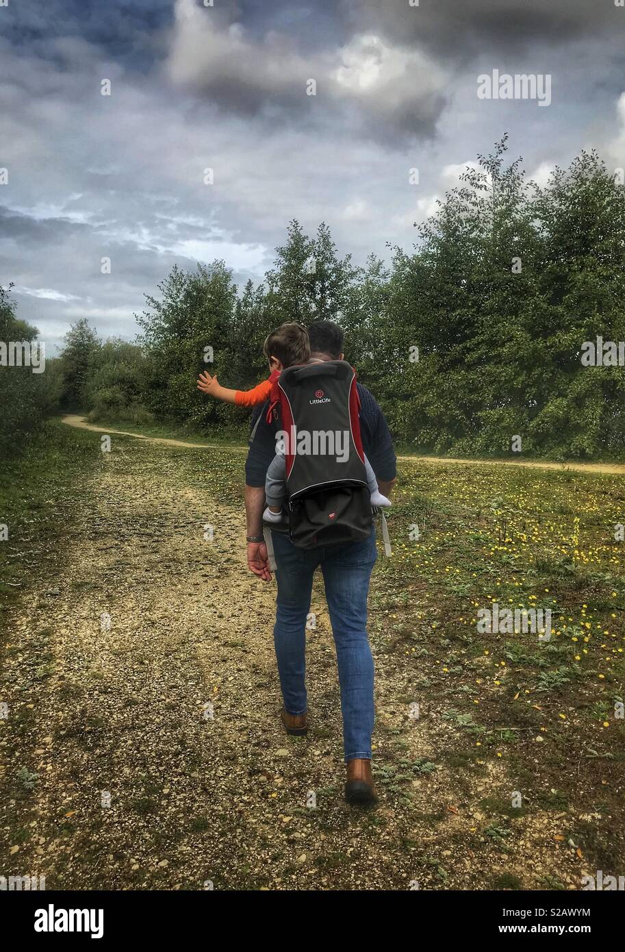 Padre figlio portante sulla sua schiena su una escursione Foto Stock