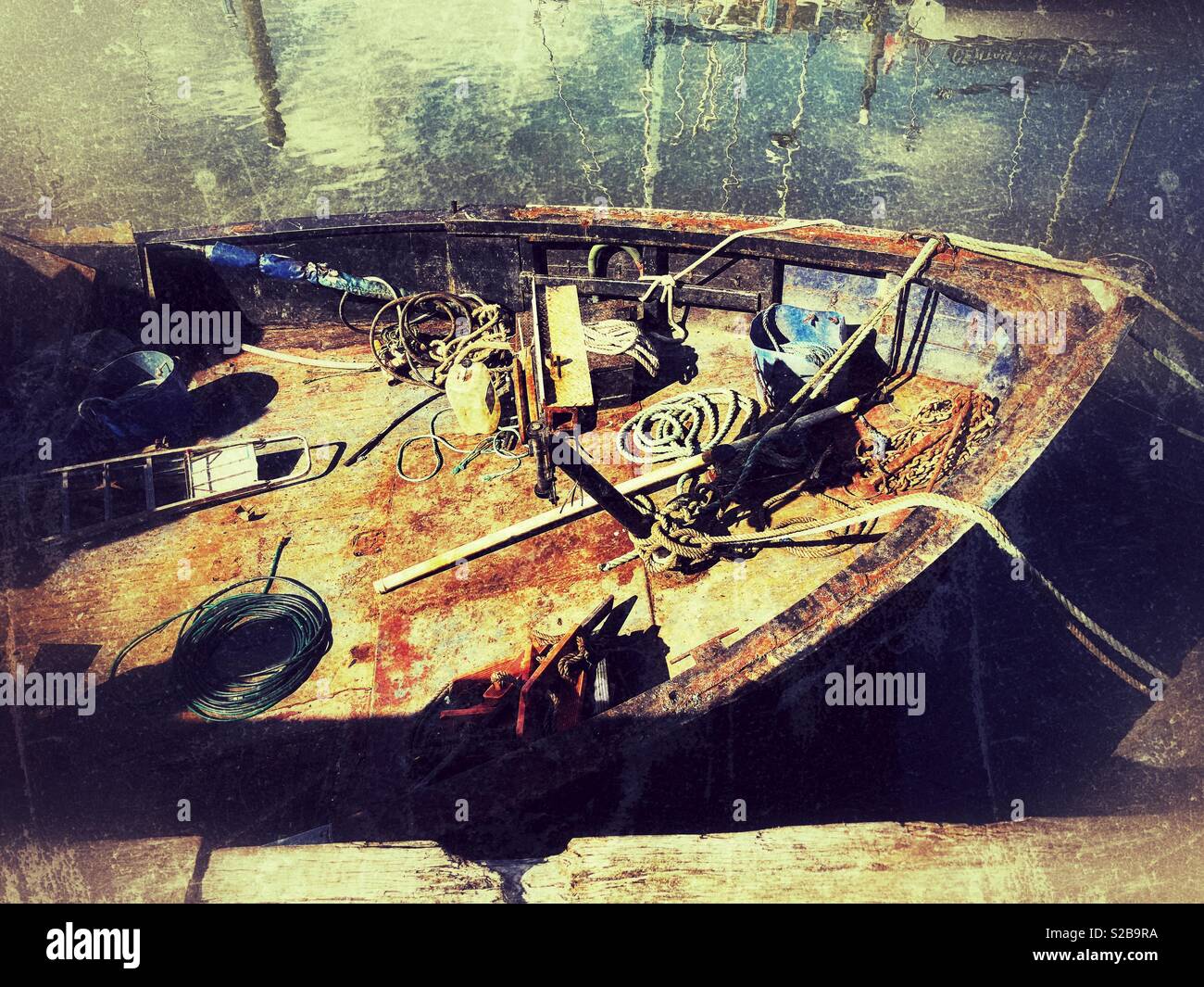Paraphernalia assortiti sul ponte di un arrugginito, vecchia barca sotto lavori di rinnovo Foto Stock