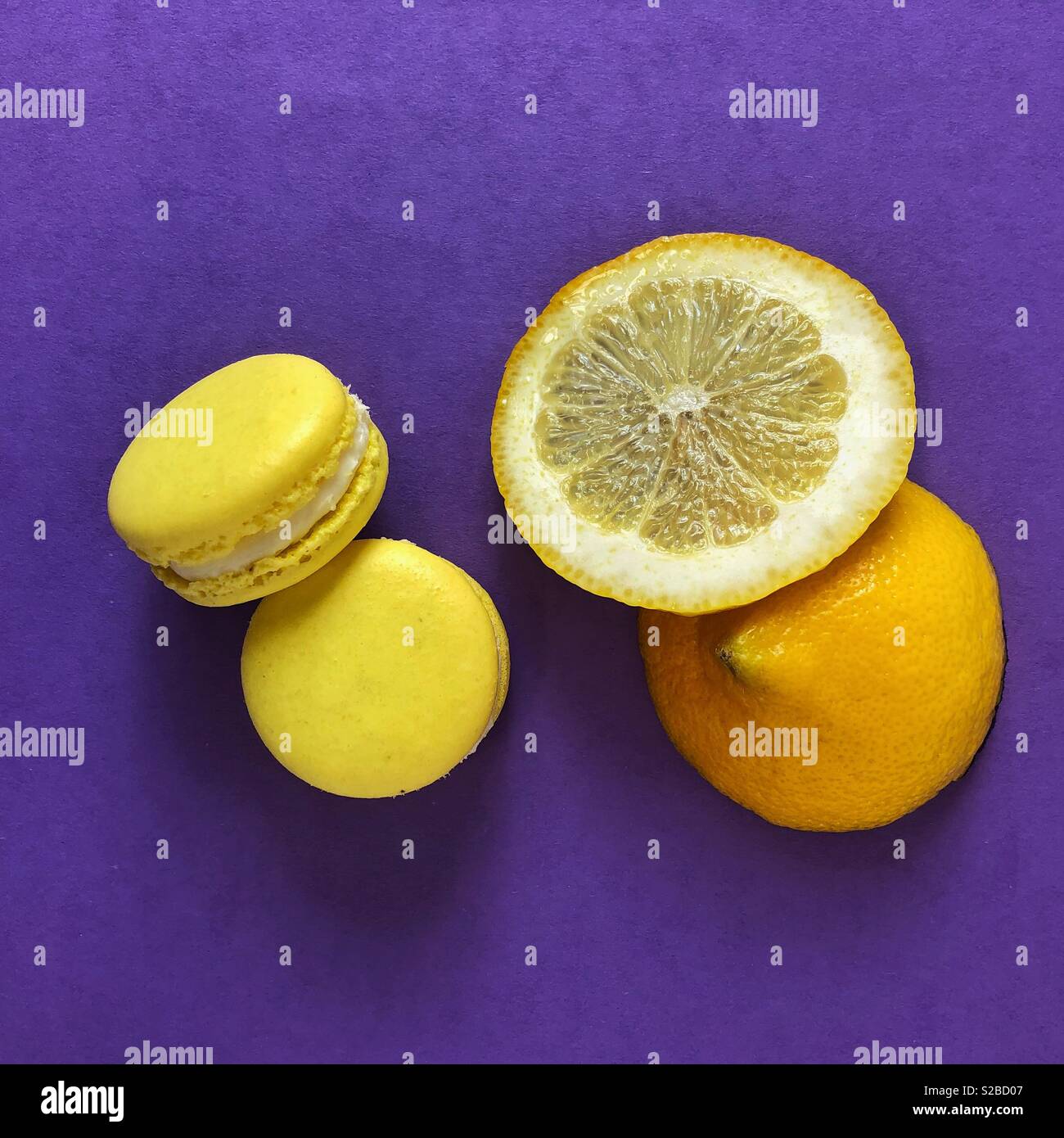 Lemon Meringue amaretti e fetta di limone su sfondo viola Foto Stock