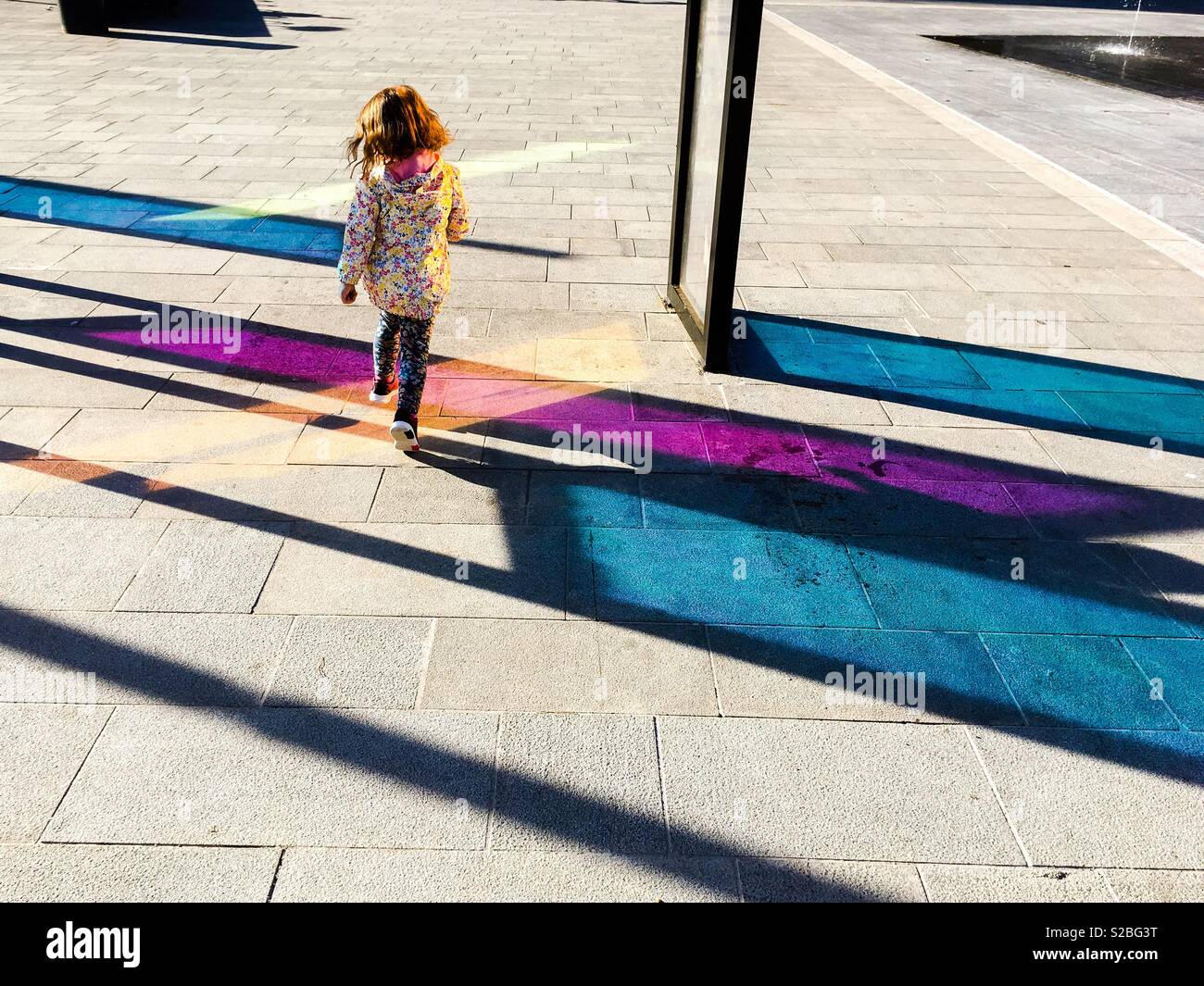 Giovane ragazza Toddler camminando sul marciapiede colorato all'aperto Foto Stock