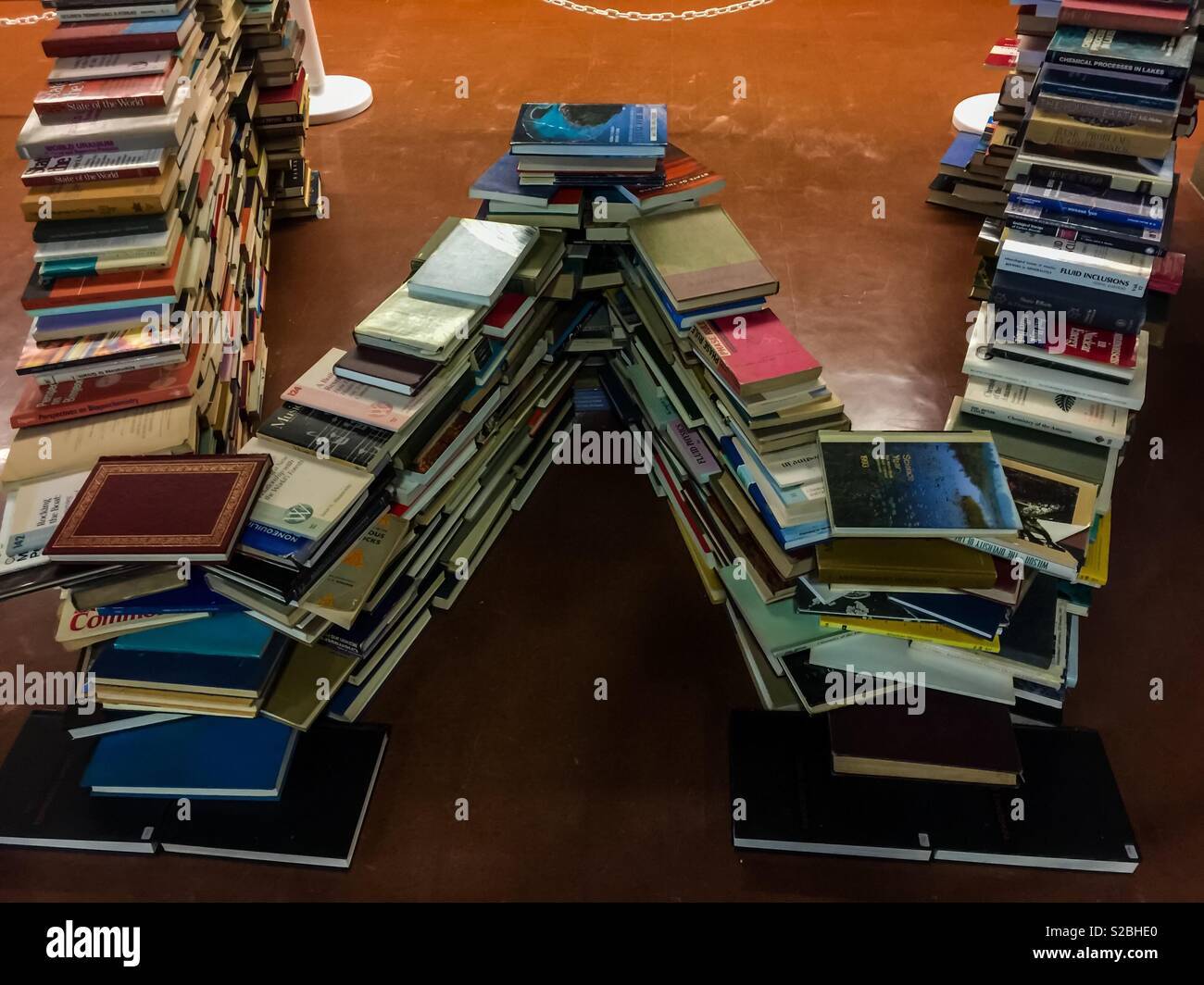 Libro scultura, lettera W o M, istituito in una biblioteca, dalla sua collezione di materiali, Ontario, Canada. W per il benvenuto. M per la mia collezione. Materiali di lettura in una biblioteca - Immagine stock catturata con smartphone