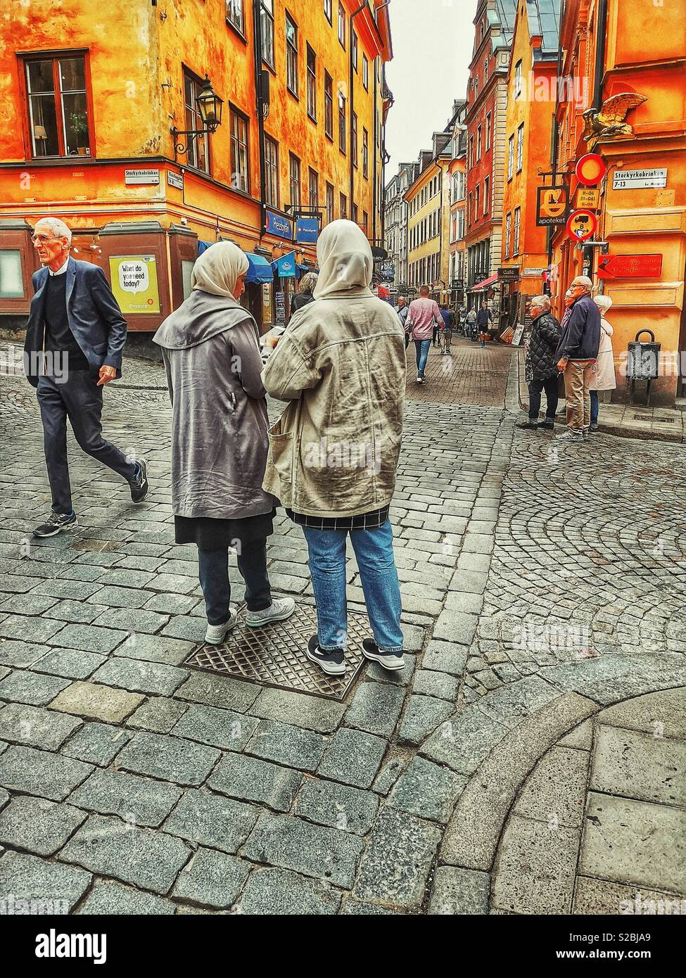 Due donne musulmane parlando in street, Gamla Stan, Stoccolma, Svezia - Immagine stock catturata con smartphone