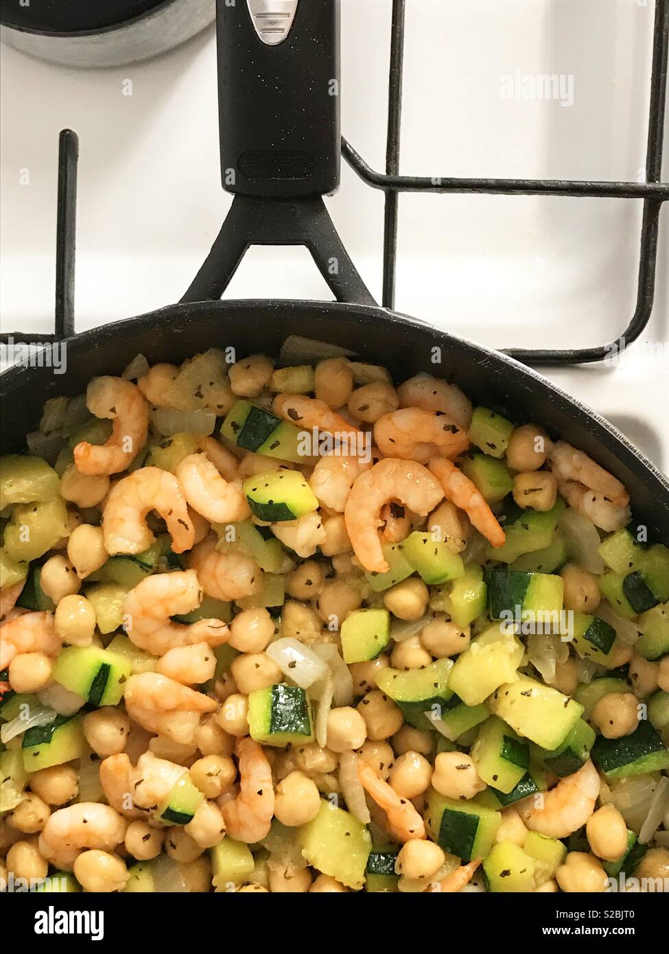 Friggere zucchine, gamberi e cipolle in una padella. Vista dall'alto. Foto Stock