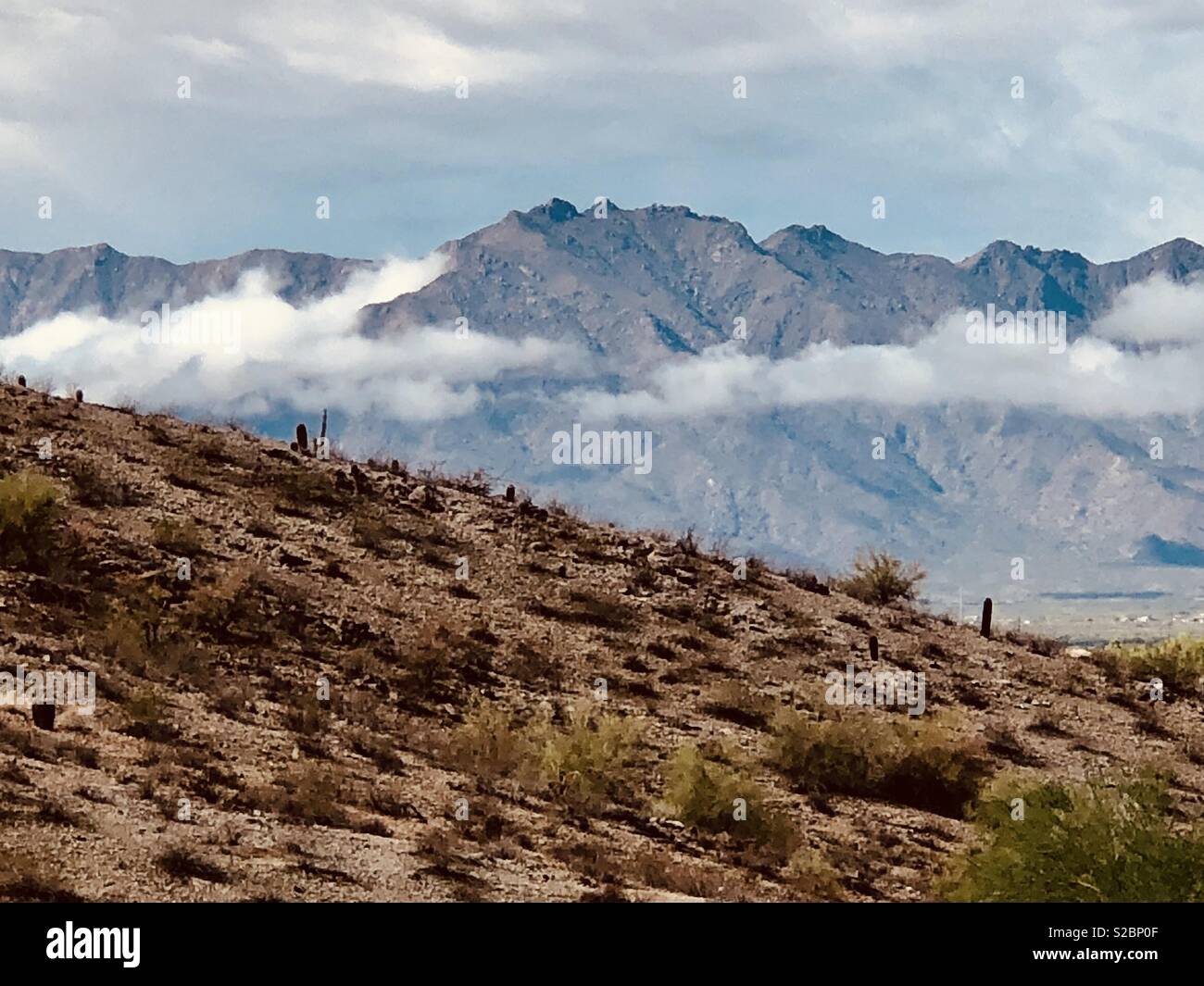 Nuvole sotto la cima della montagna Foto Stock