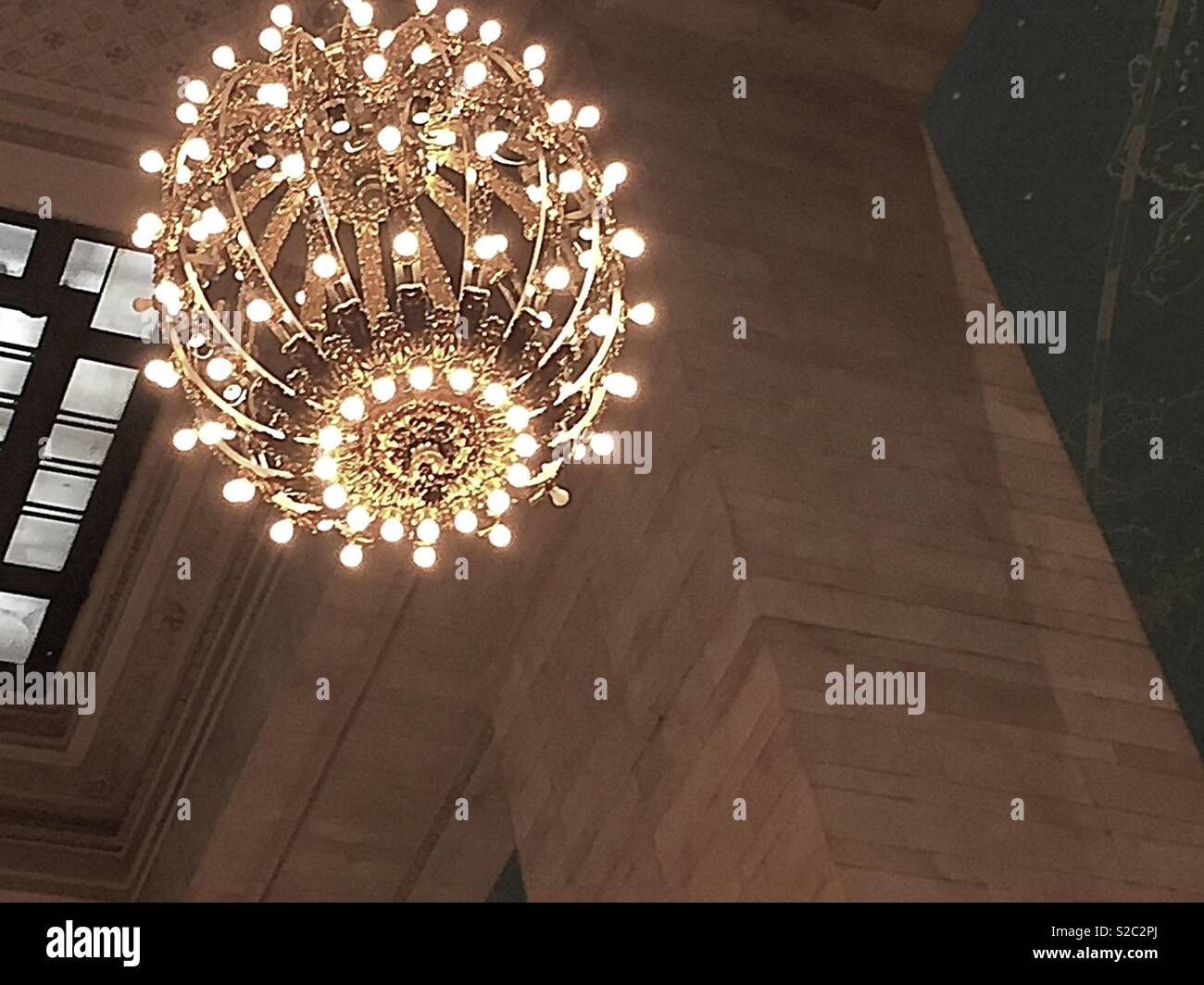 Illuminata enormi lampadari appesi al soffitto del Grand Central Terminal, NYC, STATI UNITI D'AMERICA - Immagine stock catturata con smartphone