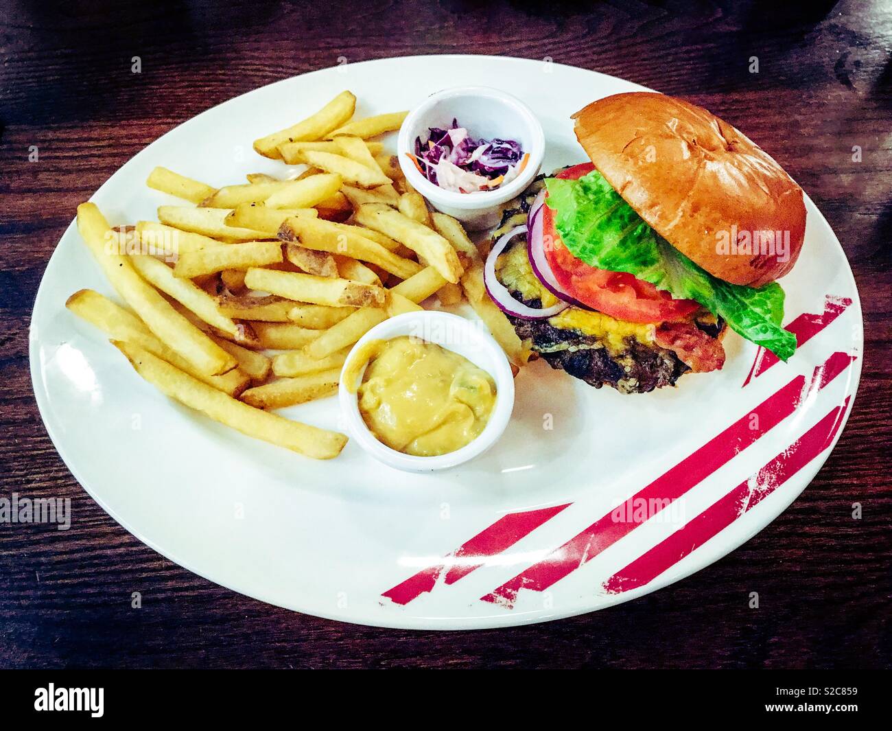 Bacon cheeseburger e patatine fritte su un piatto in un ristorante Foto Stock