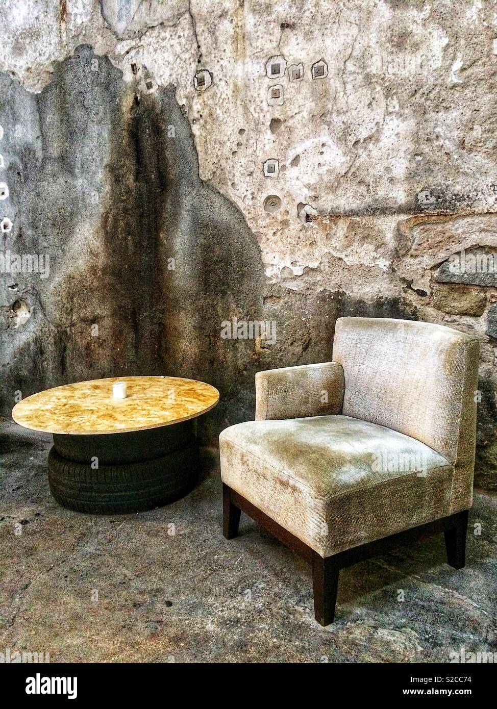 Un vecchio e vintage, poltrona e tavolo in un vecchio edificio industriale Foto Stock