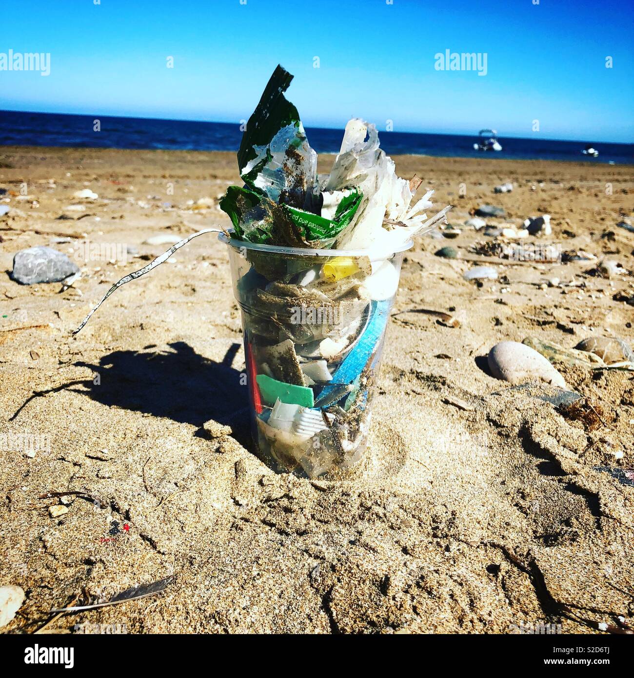 Plastica pinta mezza tazza riempita con piccole plastiche raccolto lungo una spiaggia di Creta, Grecia Foto Stock