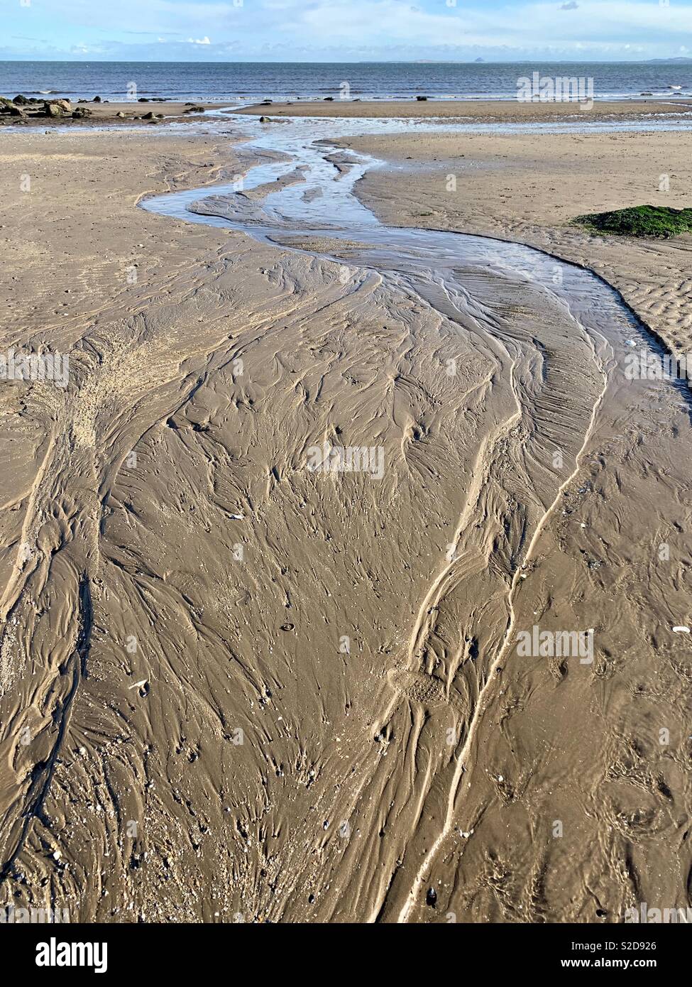I marchi di acqua a sinistra nella sabbia da una marea sfuggente Foto Stock