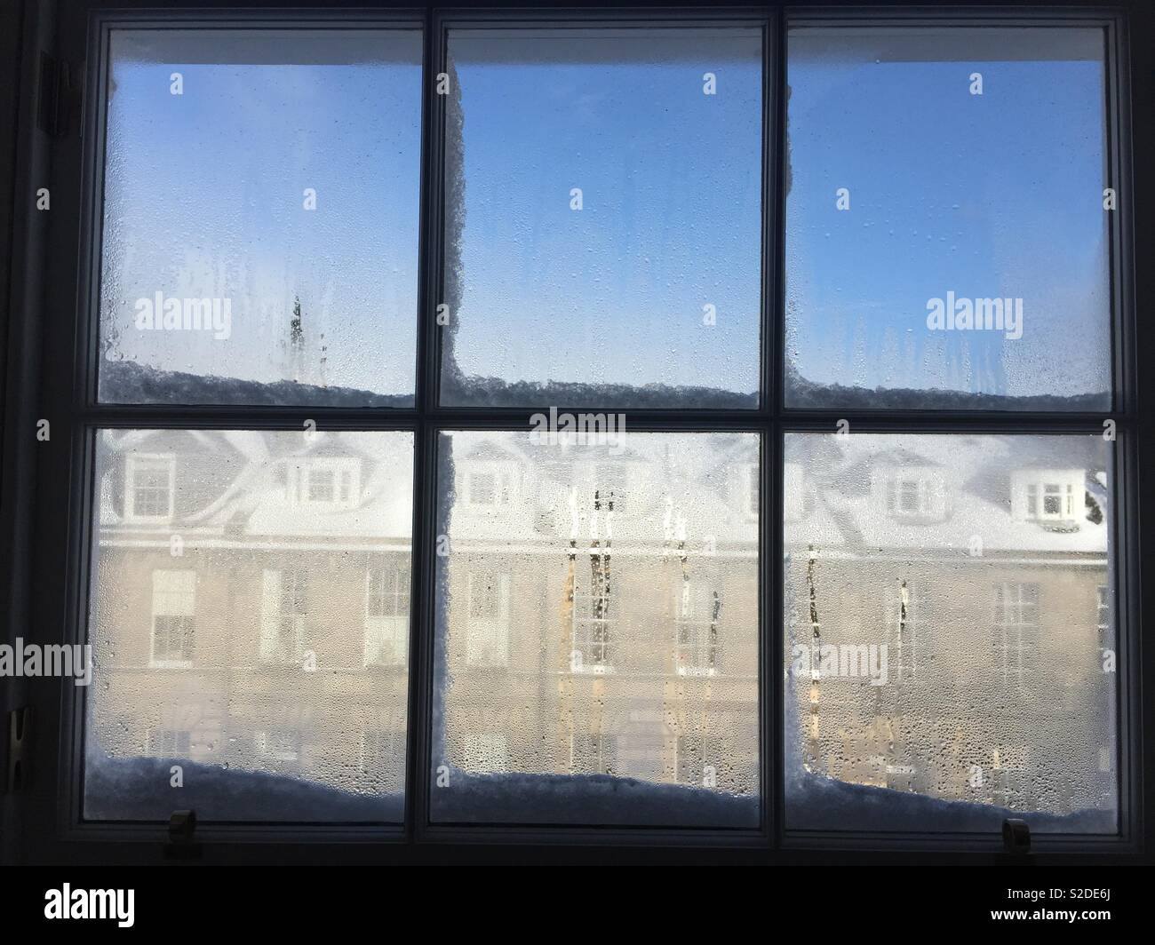 Riquadri della finestra con la formazione di condensa su una soleggiata giornata nevosa a Edimburgo in Scozia Foto Stock