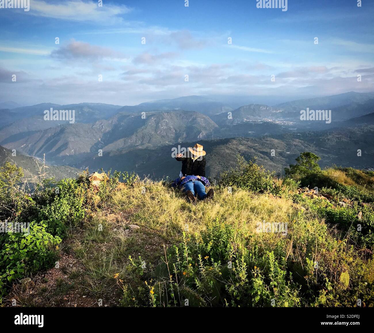 Una guida turistica esegue un nuovo rituale di età con una donna sulla sommità del Cerro del Jaguar hill in Lachatao nella Sierra Norte di Oaxaca, Messico - Immagine stock catturata con smartphone