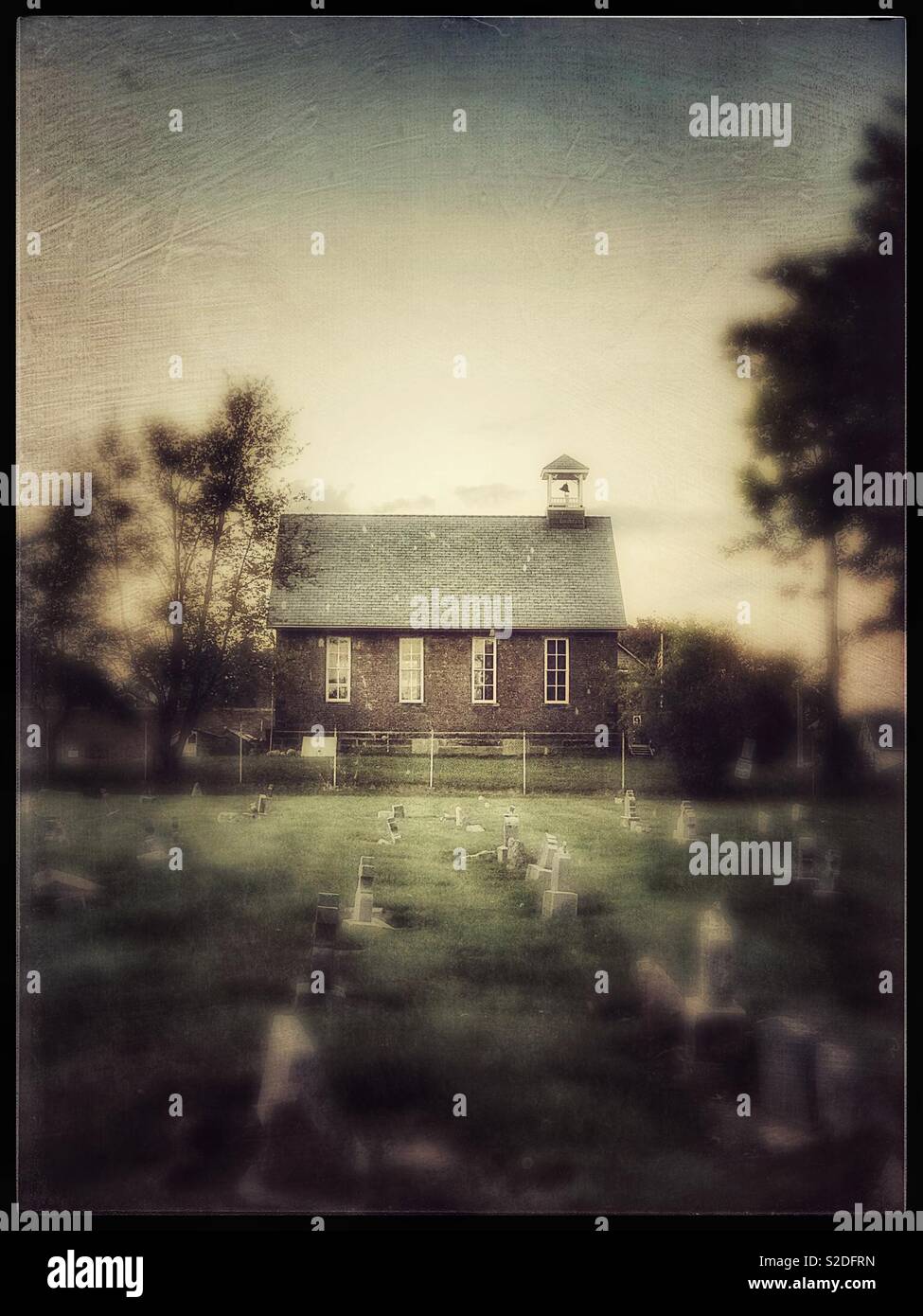 Old School House e il cimitero al tramonto - Immagine stock catturata con smartphone