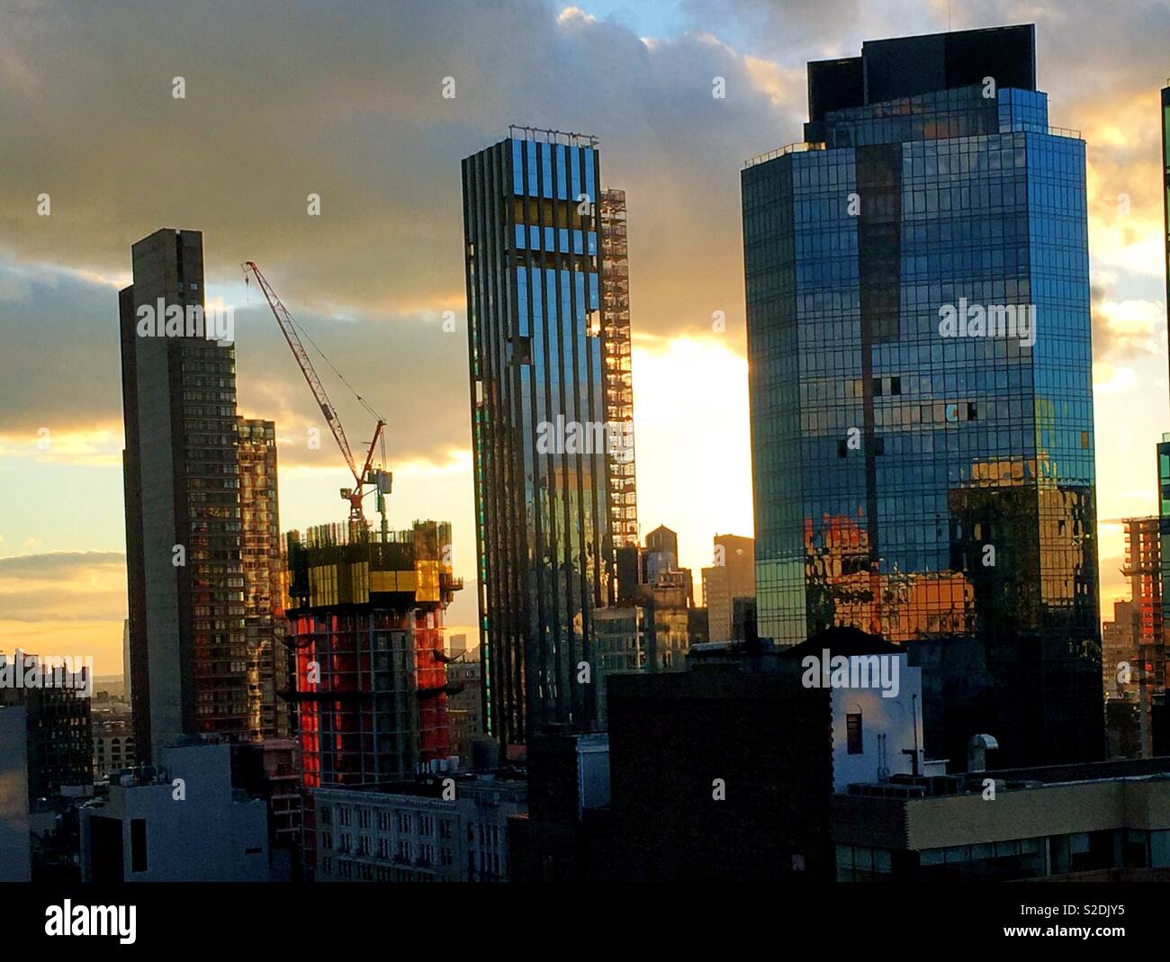 Grattacieli e un grattacielo di gru da cantiere nel centro di Manhattan al tramonto, NYC, STATI UNITI D'AMERICA - Immagine stock catturata con smartphone