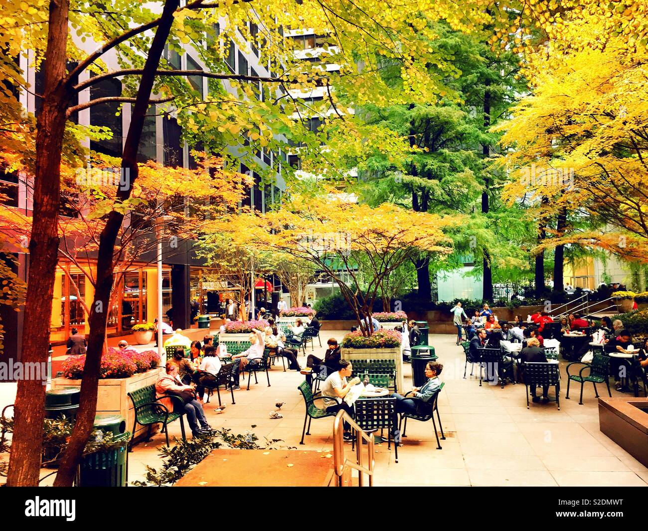 Gli impiegati e i turisti che si godono una tasca park in midtown Manhattan su una brusca caduta giorno, NYC, STATI UNITI D'AMERICA Foto Stock