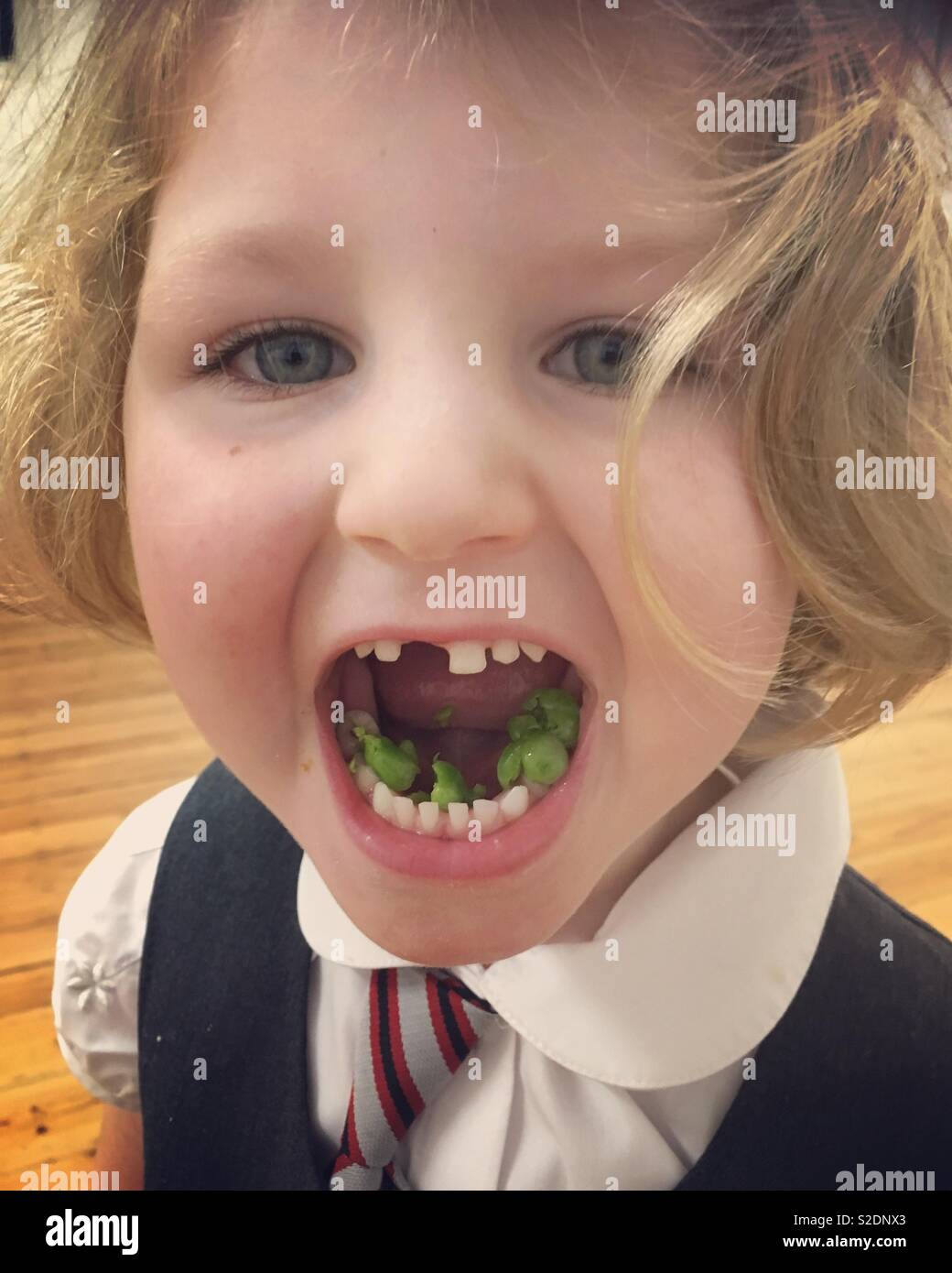 Bambino / bambino / ragazza mangiare piselli verdi come parte di una sana dieta di vegetali di verdure fresche. - Immagine stock catturata con smartphone