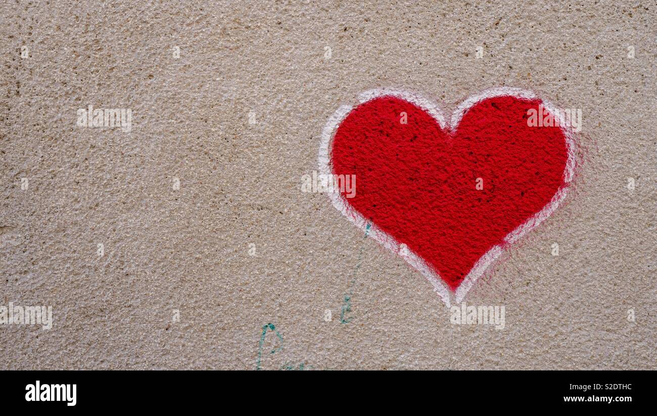 A forma di cuore ad graffiti su un muro di cemento a Valencia Foto Stock