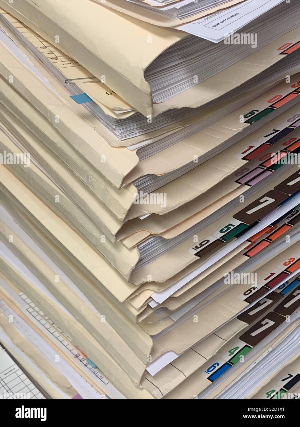 Una alta pila di carta record medico di un ufficio medico in verticale il formato dell'immagine. Foto Stock