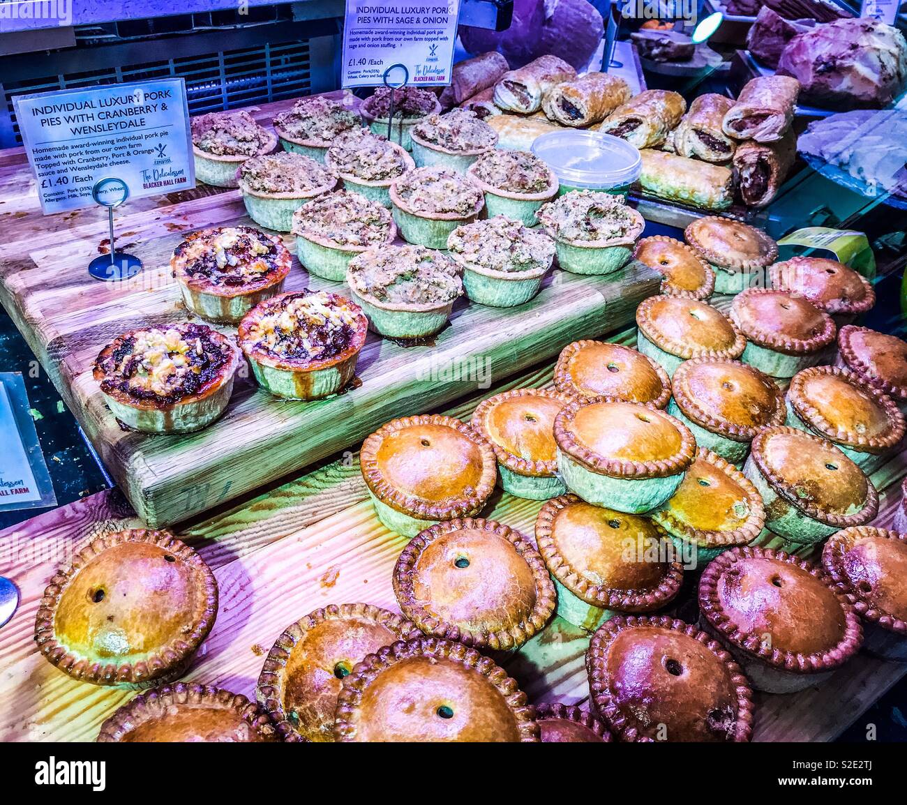 Torte di carne di maiale per la vendita in un contatore di deli - Immagine stock catturata con smartphone