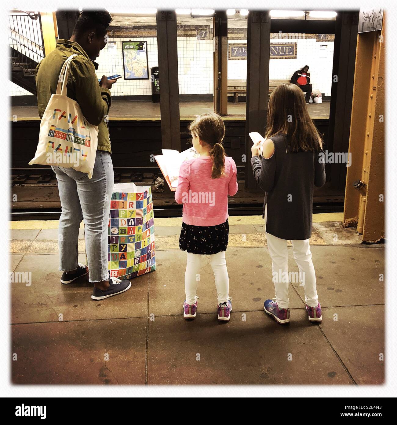 I bambini la lettura in attesa di abete la metropolitana Foto Stock