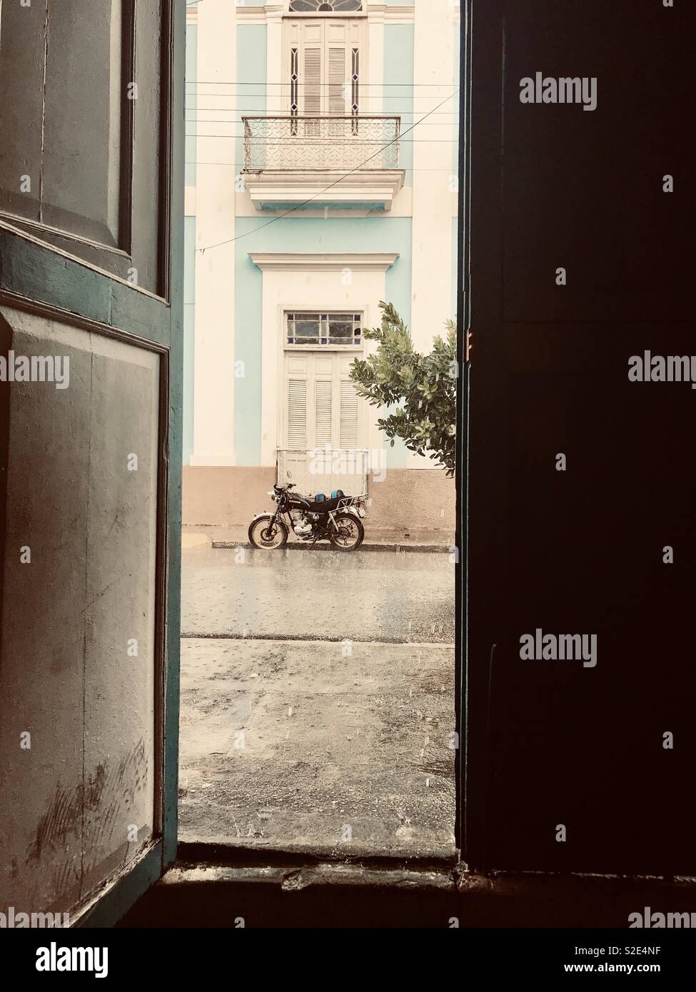 All'interno di un bar a guardare una moto sotto la pioggia battente a Cienfuegos Cuba Foto Stock