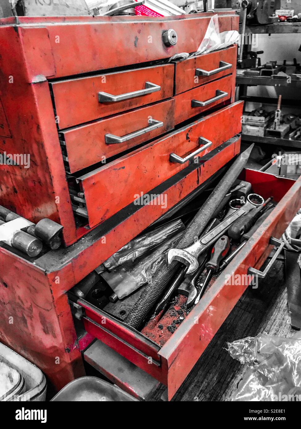 Vecchio rosso cassettiera per utensili in una fabbrica di workshop con colore selettivo Foto Stock
